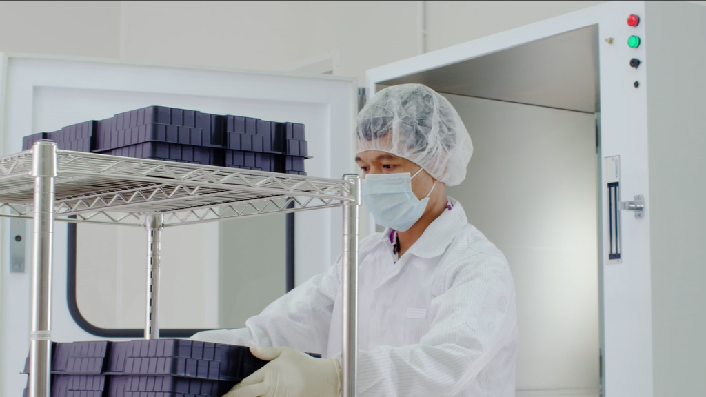 a staff wearing mask working in a clean room